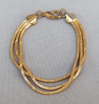 BIJUTERIAS, uma (01) pulseira feminina com três voltas em metal dourado, trançado, medindo 20cm.