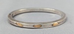 JOIA, uma (1) pulseira rígida, confeccionada em PRATA, filetes a ouro, possui pega ladrão, medindo 6,5 x 6 cm, peso aproximado 15 gr.
