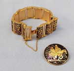 BIJUTERIAS, duas (02) peças damasquinadas de Toledo, município de Espanha. Um broche e uma pulseira confeccionados na arte Moura de embutir fios de ouro ou prata em metal como o aço preto. O broche tem representado D. Quixote e Sancho Pança e a pulseira pássaros. Medidas do broche 3,5cm de diâmetro e da pulseira 20 x 2,2cm. Aparentam não terem sido usados.