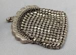ACESSÓRIO FEMININO, uma (01) bolsa porta moedas confeccionada em metal prateado, medindo 8cm x 6,5cm.