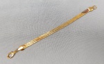 BIJUTERIAS, uma (01) pulseira feminina com três voltas em metal dourado, trançado, medindo 20cm; com mancha de teste de ouro.