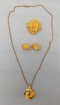 BIJUTERIAS, lote com quatro (04) peças; 1 broche; 1 par de brincos de pressão; 1 pingente dupla face; 1 corrente malha escama de cobra, confeccionados em metal dourado; medida da corrente 76cm aproximadamente.