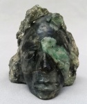 ESCULTURA, uma (01) cabeça de índio esculpida em esmeralda natural, rocha matriz (pedra da prosperidade do Amor Celestial), medindo 7 x 6 x 6cm aproximadamente; com pequeno bicado no nariz