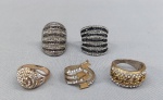 BIJUTERIAS, lote com cinco (05) anéis diversos, de diferentes modelos, confeccionados em metal dourado e prateado com pedraria; medidas aro 18/19 aproximadamente. Vide foto.