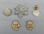 BIJUTERIAS, lote com quatro (04) peças em metal dourado e prateado com pedraria: 1 broche representando flor; 1 par de brincos para orelha furada; 1anel aro 18; e 1 pingente no formato de coração.