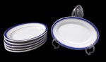 MAUÁ, Seis mini travessas em porcelana esmaltada na tonalidade branca, decorada espessa faixa azul e filetada a ouro. Med.: 15,x11cm.