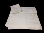 CAMA, MESA E BANHO, Toalha de mesa em linho na tonalidade cinza, rebordado com flores e folhagens em linha branca, medindo: 220,5x178cm; acompanha 8 guardanapos, medindo: 41 x 41 cm.