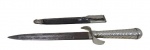 CUTELARIA, Faca de coleção em metal espessurado a prata, lamina em metal (apresenta oxidações, cabo cinzelado em gomos torcidos, bainha em couro com guarnição em metal (desgastada). Med.: 28cm,