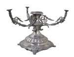 METAL PRATEADO, Base para fruteira de 4 pratos em metal espessurado a prata, ricamente cinzelado por motivos florais, gomos e perolados, braços com acabamentos vazados. Braços quebrados, roscas desgastadas e mossas. Peça no estado. Med.: 26,5x33x34cm.