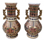 PORCELANA ORIENTAL, Par de vasos/ânfora em porcelana esmaltada em rica policromia e relevo, decorado por elementos vegetalistas e perolados, alça e realces em vasta douração. Med.: 34x11,5cm.