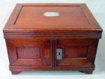 DIVERSOS, Caixa para faqueiro em madeira, frontal com 2 portas com fechaduras em metal (falta 1), tampa superior articulável com placa em prata inglesa com monograma "BB", interior com 4 gavetas com puxadores em metal, forradas em cetim, apresenta marcas do tempo, alças laterais em metal, falta 1. Med.: 30x47x38cm.