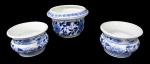 PORCELANA, Três cachepots em porcelana esmaltada na tonalidade branca, com pintura de flores e folhagens na tonalidade azul. Med.: 9x14cm / 7x10cm.