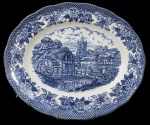 RAVENSDALE POTTERY, Travessa oval em faiança vitrificada, com pintura de flores, folhagens e paisagem na tonalidade azul. Med.: 30x25cm.