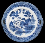 PORCELANA, Prato para bolo em porcelana esmaltada na tonalidade branca, com pintura de elementos geométricos, arabescos, volutas e parte central dita: Pombinho Willow na tonalidade azul. Alças laterais vazadas. Med.: 27,5x27cm.