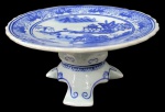 PORCELANA ORIENTAL, Fruteira de pé em porcelana esmaltada, com pintura de paisagens, elementos geométricos e folhagens na tonalidade azul, apoiado sobre 3 pés com decoração de arabescos. Med.: 10x20CM.