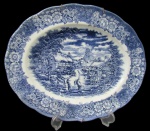 RAVENSDALE POTTERY, Travessa oval em faiança vitrificada, com pintura de flores, folhagens e paisagem na tonalidade azul. Med.: 30x25cm.