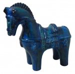 ESCULTURAS, Escultura em cerâmica vitrificada representando cavalo, com pintura predominante na tonalidade azul e realces em verde. Med.: 26x25,5x11cm.