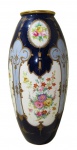 LIMOGES, França, Grande vaso em porcelana esmaltada na tonalidade azul, com pintura de flores e folhagens em policromia, arabescos, concheados e volutas ricamente realçadas a ouro. Para segurança, essa peça só poderá ser enviada por isopor. Med.: 43x11,5cm.