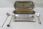 METAL PRATEADO, Lote com 6 peças, sendo: A) 2 bandejas em metal espessurado a prata da manufatura BELINI, ricamente cinzelado por motivos florais, necessita banho (33x14cm), B) 1 travessa em aço inox (23x15cm) e C) 3 talheres, sendo: 1 colher para arroz, 1 garfo para salada e 1 colher bailarinas, todos confeccionados em metal espessurado a prata.