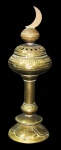 METAL DOURADO, Incensário em metal dourado, ricamente cinzelado, encimado por meia lua sobre esfera, coluna cilíndrica apoiado sobre base escalonada com placas cinzeladas representando folhas. Med.: 31cm.