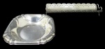 METAL PRATEADO, Lote com duas peças em metal espessurado a prata, sendo: A) 1 pãozeira da manufatura WOLFF, cinzelado por sulcos torcidos e bordas onduladas (22x22cm) e B) 1 travessa para rocambole, decoração vazada e bordas onduladas (6x35x11cm).