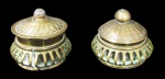 BRONZE, Duas caixas em bronze indiano polido, corpo vazado, tampa cinzelada, 1 com pega em pedra e 1 com pega em esfera. Med.: 6x6cm. 1 com interior da tampa solto.