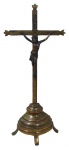 ARTE SACRA, Crucifixo confeccionado em bronze, Cristo sobreposto, cinzelado de motivos florais, apoiado sobre base escalonada sobre 3 pés curvos. Med.: 32,5x14cm.