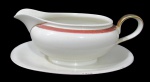 BAVARIA, Molheira fixada a presentoir em porcelana esmaltada a tonalidade creme, com pintura de faixa na tonalidade vinho com realces florais em ouro. Alça restaurada possuindo colado. Med.: 10x21,5x8cm.