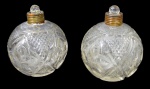 CRISTAIS, Par de perfumeiros em cristal translucido, ricamente lapidado por pingos de diamante, flores e sulcos em baixo relevo, fundo estrelado, ambos faltam acabamentos da tampa. Apresenta bicados internos nas tampas. Med.: 10cm.