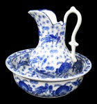 PORCELANA, Bacia e gomil em porcelana esmaltada na tonalidade branca, com pintura de flores, folhagens, pássaros e arabescos na tonalidade azul. Gomil possui colado na borda. Med.: Gomil: 28,5x20x14cm / Bacia: 10,5x34,5cm.