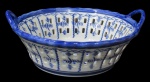 PORCELANA, Fruteira em porcelana esmaltada na tonalidade branca, formato de cesta, com pintura de paisagem oriental na tonalidade azul, galeria vazada, bordas e alças realçadas em azul. Med.: 10x25x23cm.