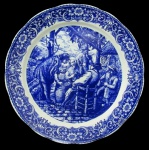 DELFT, Medalhão em porcelana esmaltada na tonalidade branca, borda decorada com motivos florais e centro com pintura de cena campestre na tonalidade azul. Marcado no fundo. Med.: 34,5cm.