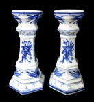PORCELANA ORIENTAL, Par de castiçais em porcelana esmaltada na tonalidade branca, formato sextavado, com pintura de flores, folhagens e arabescos na tonalidade azul. Med.: 26x10x10cm.