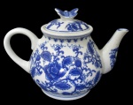 PORCELANA, Bule para chá em porcelana esmaltada na tonalidade branca, com pintura de flores e folhagens na tonalidade azul, pega da tampa representando borboleta. Med.: 17x24x10cm.