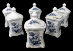 FAIANÇA, Seis porta temperos em faiança vitrificada na tonalidade branca, decorada por arabescos em relevo e pintura de flores e folhagens e inscrição com nome do tempero na tonalidade azul, pega da tampa em bilro e base escalonada. 1 possui bicado e 2 com falhas na esmaltagem. Med.: 11,5x6,5x6cm.
