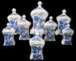 DELFT, Nove porta temperos em faiança vitrificada na tonalidade branca, decorada por arabescos em relevo e pintura de flores e folhagens e inscrição com nome do tempero na tonalidade azul, pega da tampa em bilro e base escalonada. Med.: 24x13x11,5cm / 19x10x10cm / 16x8,5x7cm / 12,5x7x6,5cm.