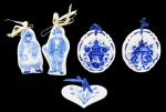 PORCELANA, Lote com 5 placas decorativas em porcelana esmaltada na tonalidade branca, sendo: A) 2 com pintura de camponeses na tonalidade azul (11,5x6cm / 12,5x7cm), B) 1 em formato de coração com pintura de flores e folhagens na tonalidade azul (9,5x7cm) e C) 2 com pintura de paisagem oriental na tonalidade azul, manufaturado no verso (11x9cm).