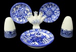 PORCELANA/FAIANÇA, Lote com 6 peças, sendo: A) ALCOBAÇA, 1 floreira em faiança vitrificada, com pintura de flores e folhagens na tonalidade azul, compartimento para 5 flores, apresenta bicado na borda (8x10cm), B) Saleiro e pimenteiro em porcelana esmaltada na cor branca, com pintura de arabescos, flores, folhagens e elementos geométricos na tonalidade azul (8cm) e C) 3 pratinhos decorativos em faiança vitrificada com pintura de flores, arabescos e elementos geométricos na tonalidade azul, manufatura no verso (11cm).