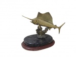 ESCULTURAS, Troféu de pesca em bronze representando Marlin, apoiado sobre base escalonada de madeira e mármore. Med.: 19x29x16cm.