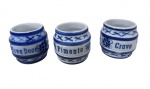 MONTE SIÃO, Minas Gerais, Três porta condimentos em porcelana esmaltada na tonalidade branca, pintura floral na tonalidade azul com inscrições: ERVA DOCE, CRAVO E PIMENTA, todos sem tampa. Med.: 6,5x6cm.