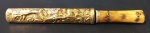 COLECIONISMO/CUTELARIA - Faca de caça com cabo em osso polido, bainha e guarnições em metal dourado, decorado com figuras orientais em relevo. Med.: 15cm.
