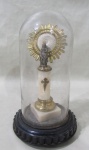 ARTE SACRA, Redoma em vidro translucido, fixado sobre peanha em plástico rígido decorado em gomos, interior com imaginária Nª Senhora do Pilar. Med.: 21,5x12cm.