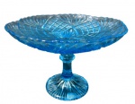 VIDROS, Fruteira de pé em vidro na tonalidade azul, decorado por sulcos e bico de jaca, bordas onduladas, apoiado sobre base circular. Med.: 12x17cm. Possui bicado na base.