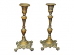 BRONZE, Par de castiçais em bronze, corpo no feitio balaustre, apoiado por 4 pés em garra, rico cinzelado de folhagens. Med.: 22,5cm.