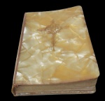 ARTE SACRA, Missal confeccionado em plástico rígido no feitio de madrepérola, crucifixo com inscrições adornados em ouro, apresenta sinais do tempo. Med.: 11,5x7,5cm.