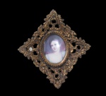 FOTOGRAFIA, Quadro camafeu representando figura feminina, moldura em resina com decoração floral e perolada com vazados, vidro boleado e pintura em papel. Med.: 15,5x14cm.