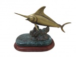 ESCULTURAS, Troféu de pesca em bronze representando Marlin, apoiado sobre base escalonada de madeira e mármore. Med.: 19,5x30x13,5cm.