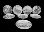 PORCELANA, Oito pratinhos decorativos em porcelana esmaltada na tonalidade branca, com pintura de cidades e marcas distintas. Med.: 9,5cm.