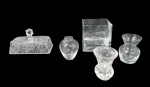 CRISTAIS/VIDROS, Lote com 5 peças, sendo: A) 3 pequenos vasos, sendo 2 em vidro e 1 em cristal translucido (maior: 8x5,5cm / menor: 7,5x6cm, B) 1 vaso em vidro translucido, formato quadrado (10x10x10cm) 1 bicado na borda e C) 1 tampa de manteigueira em cristal translucido, ricamente lapidado por estrelas e cata ventos em baixo relevo (9x15x7cm).