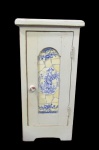 MOBILIARIO, Pequeno móvel de parede, confeccionada em madeira patinada na cor creme, porta com incrustações de azulejos representando figura feminina a colheita na tonalidade azul, interior com 1 prateleira, possui falhas no puxador. Med.: 45x22x20,5cm.